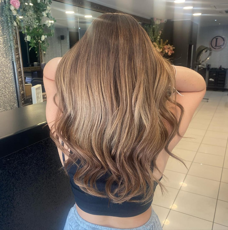 Back of womans sandy-blonde / brown beach waves hair